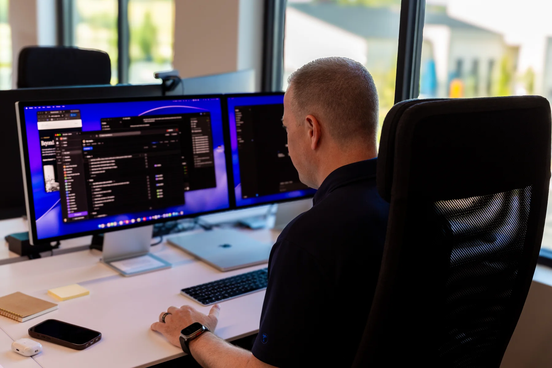 Aaron Klein working at his desk in front of two computer displays.