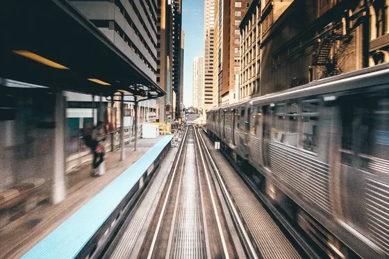 A train moves through a city rail corridor.