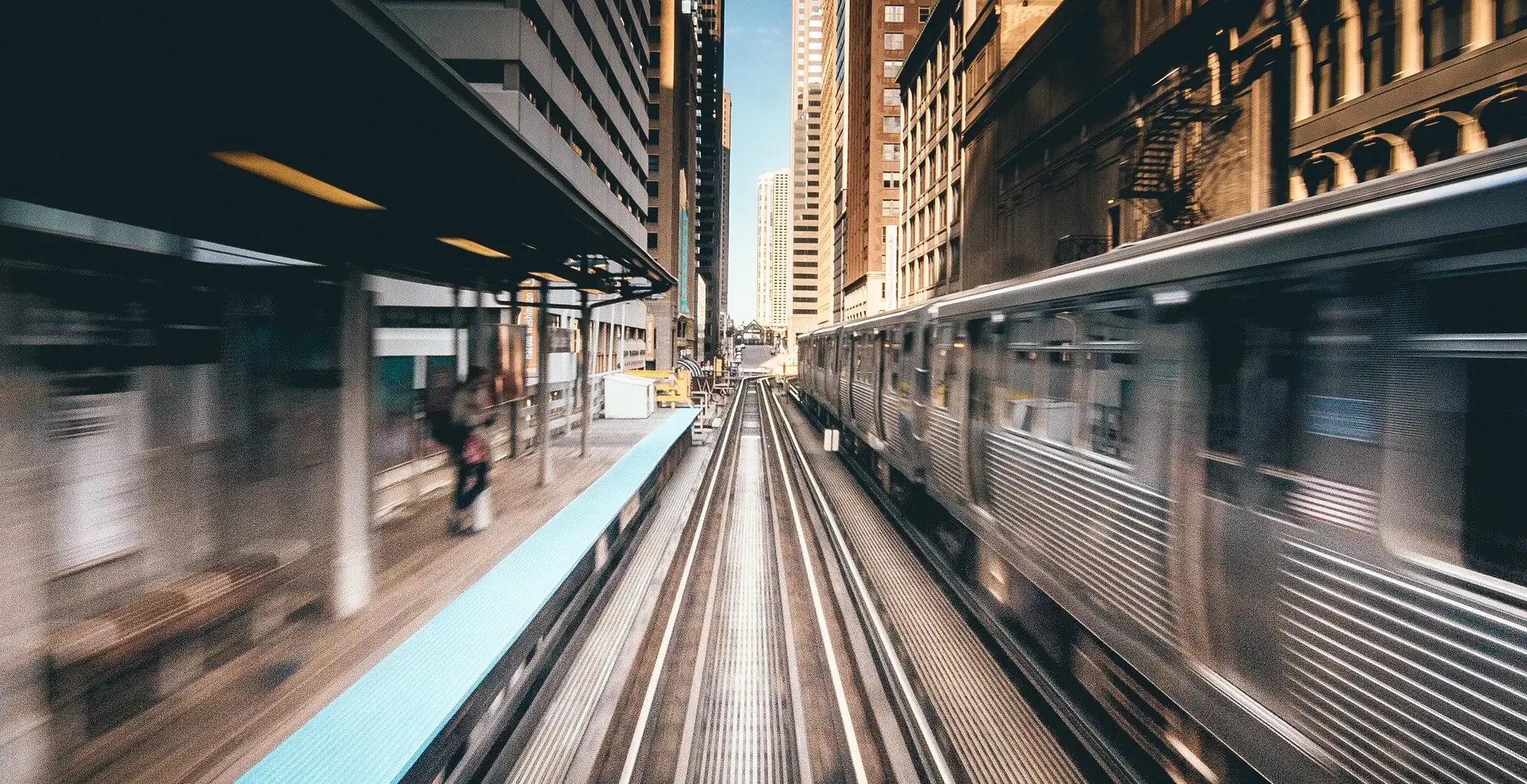 A train moves through a city rail corridor.