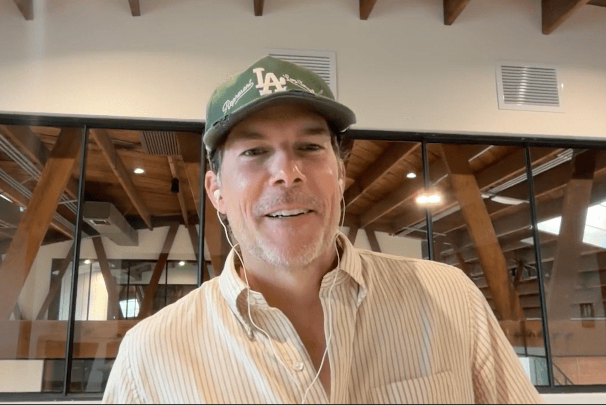 Jason Wenk wearing a green Los Angeles Dodgers cap during a remote podcast conversation.