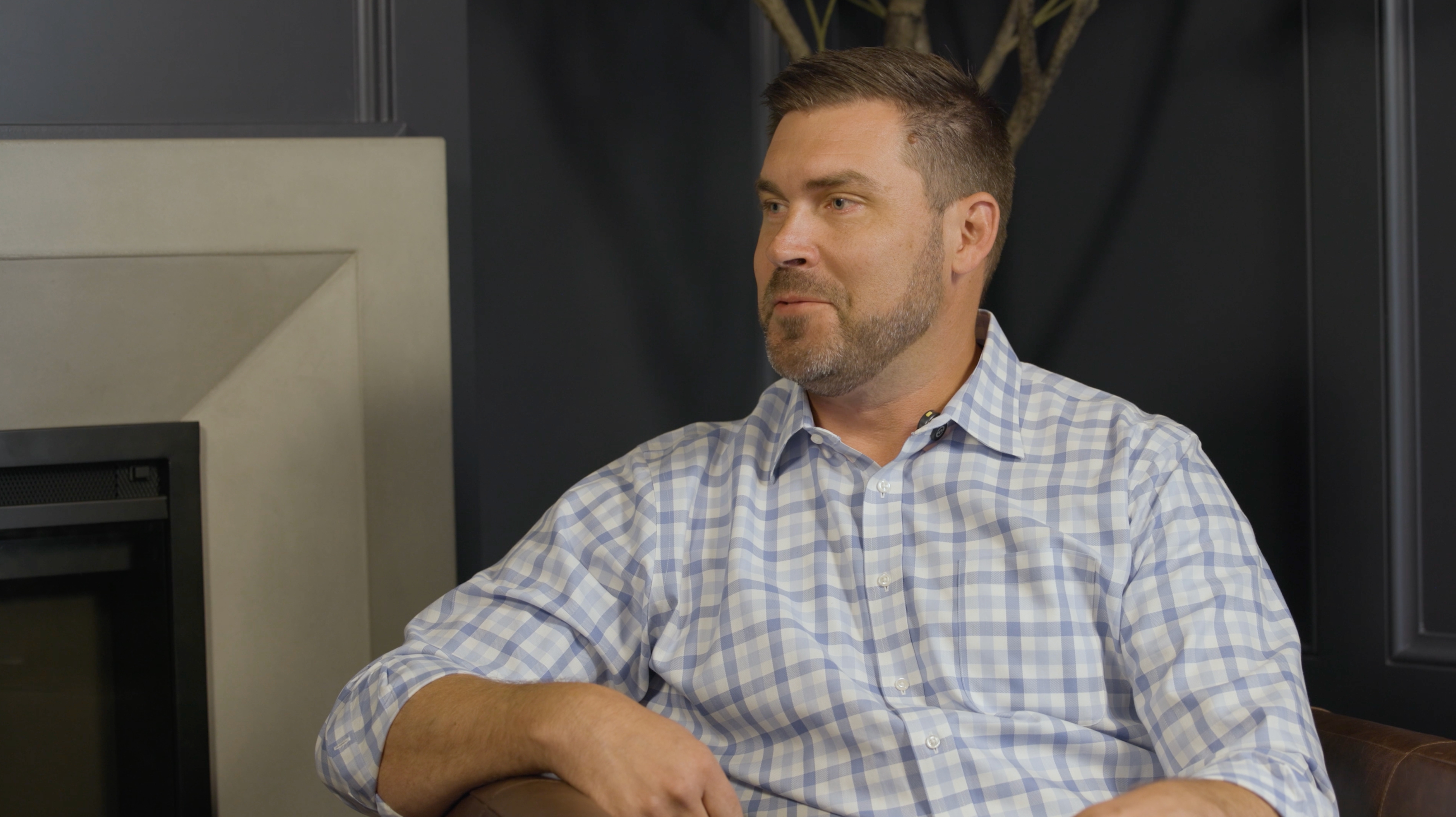 Brian Deely speaking into a studio microphone during a conversation with Aaron Klein.