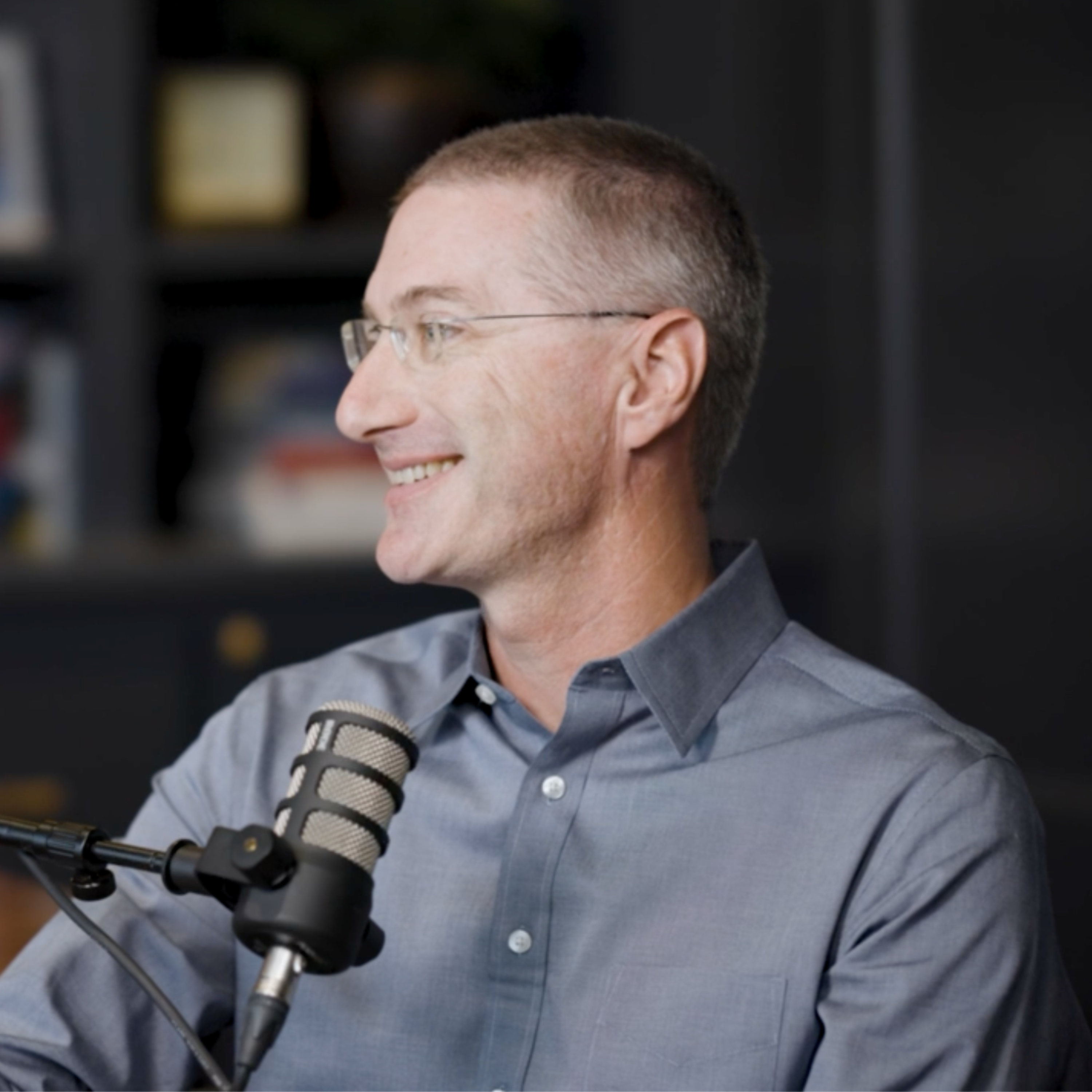 J.D. Mullin speaking into a studio microphone during a conversation with Aaron Klein.