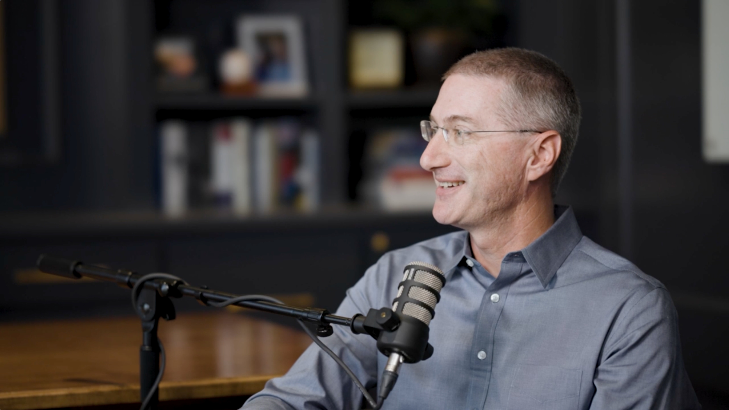 J.D. Mullin speaking into a studio microphone during a conversation with Aaron Klein.
