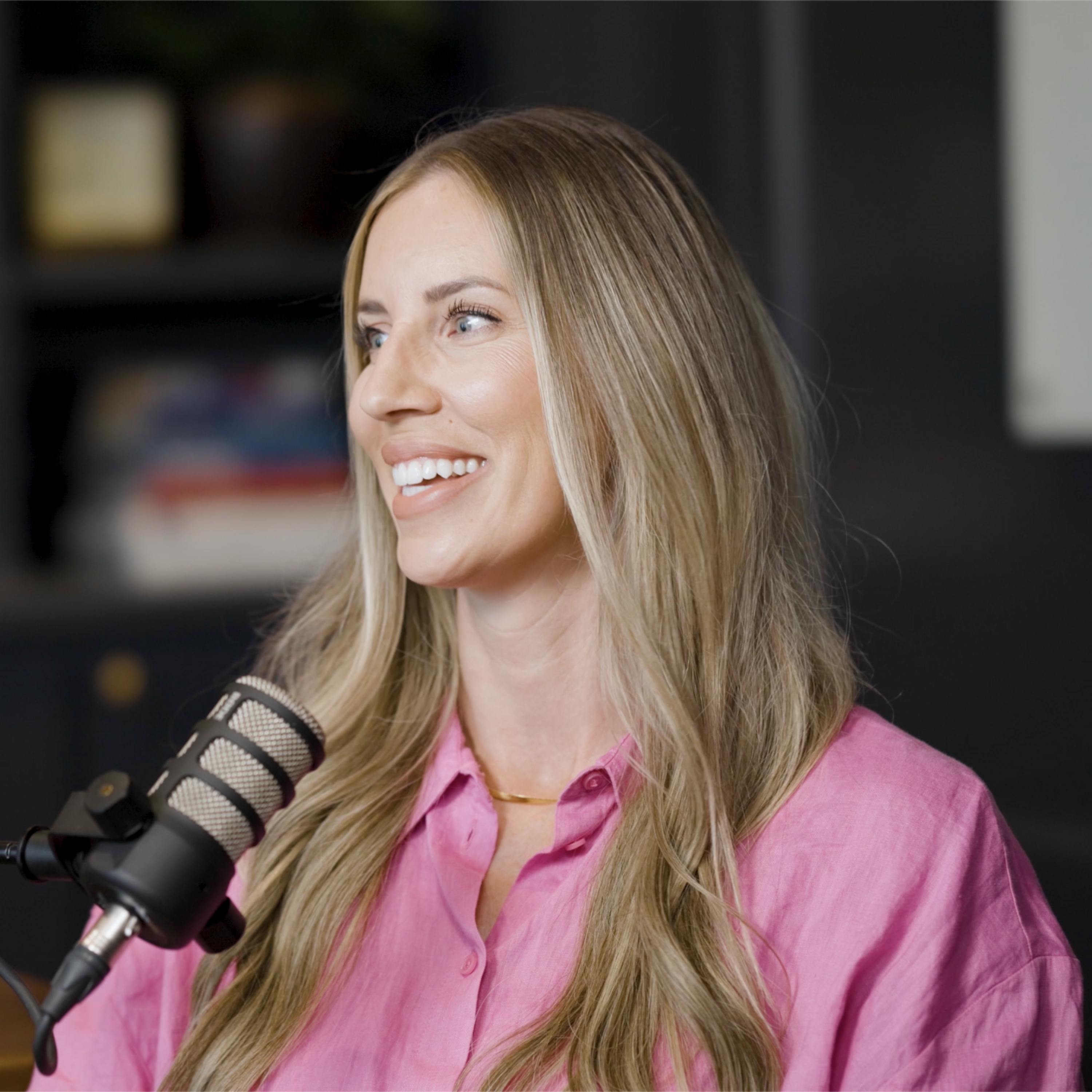 Sheena Jester speaking into a studio microphone during a conversation with Aaron Klein.